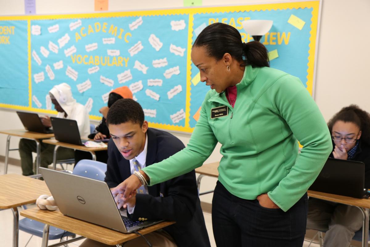 Shana White helps student with a problem on the computer
