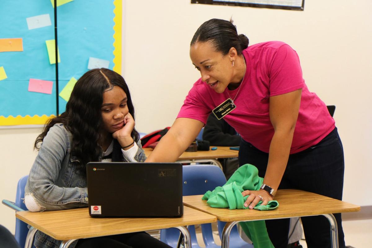 Teacher helps student with problem.