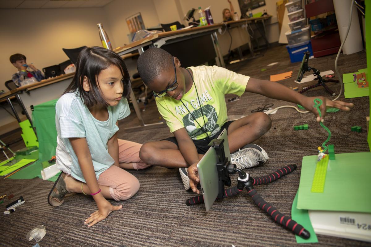 Kids work on coding project at college of computing summer camp.