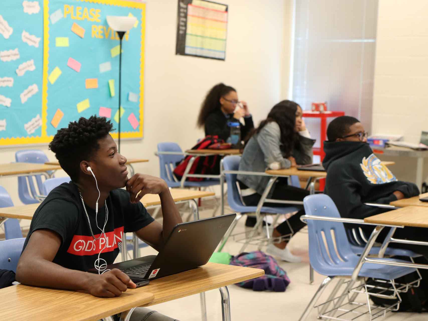 Kids sit in classroom.
