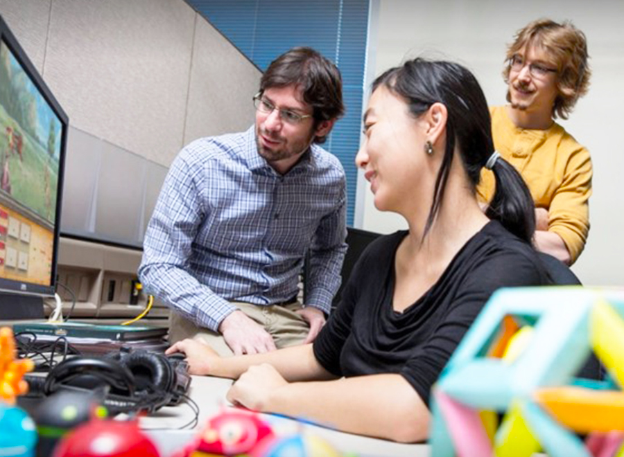 Group works on video game on computer