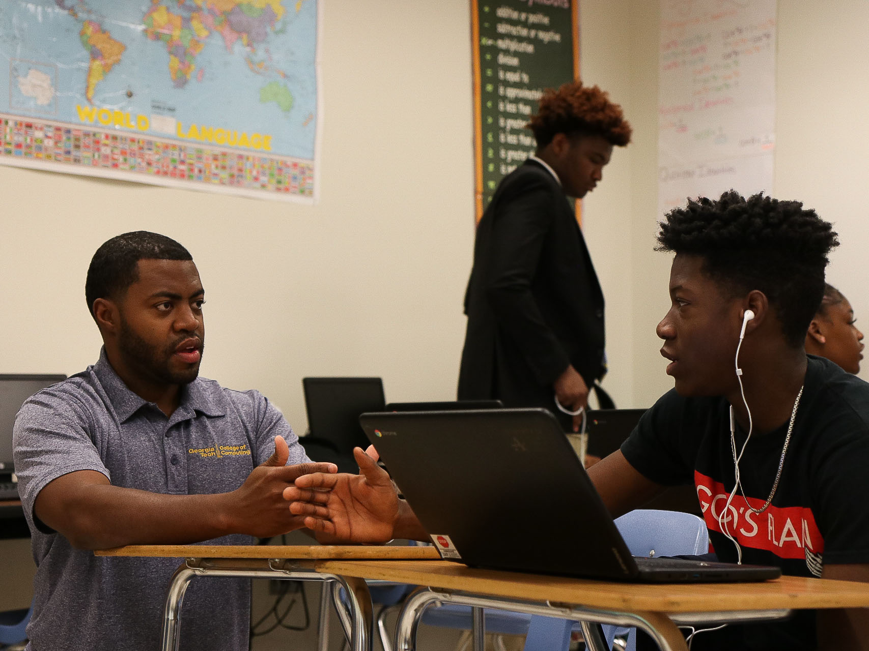 Teacher helps student in class.