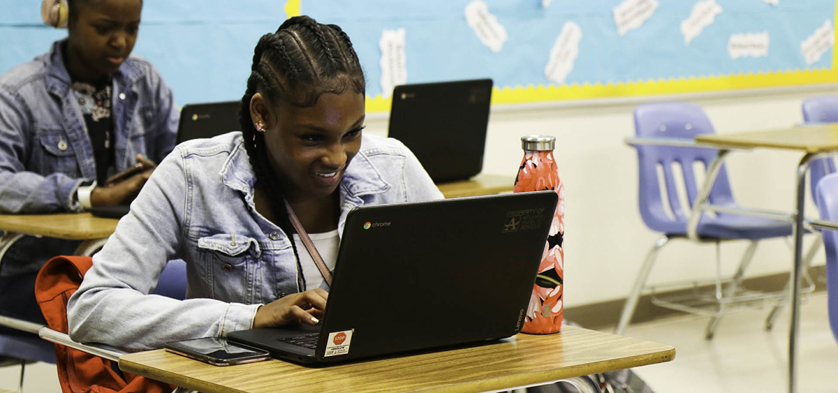 Girl studies on computer in class. 