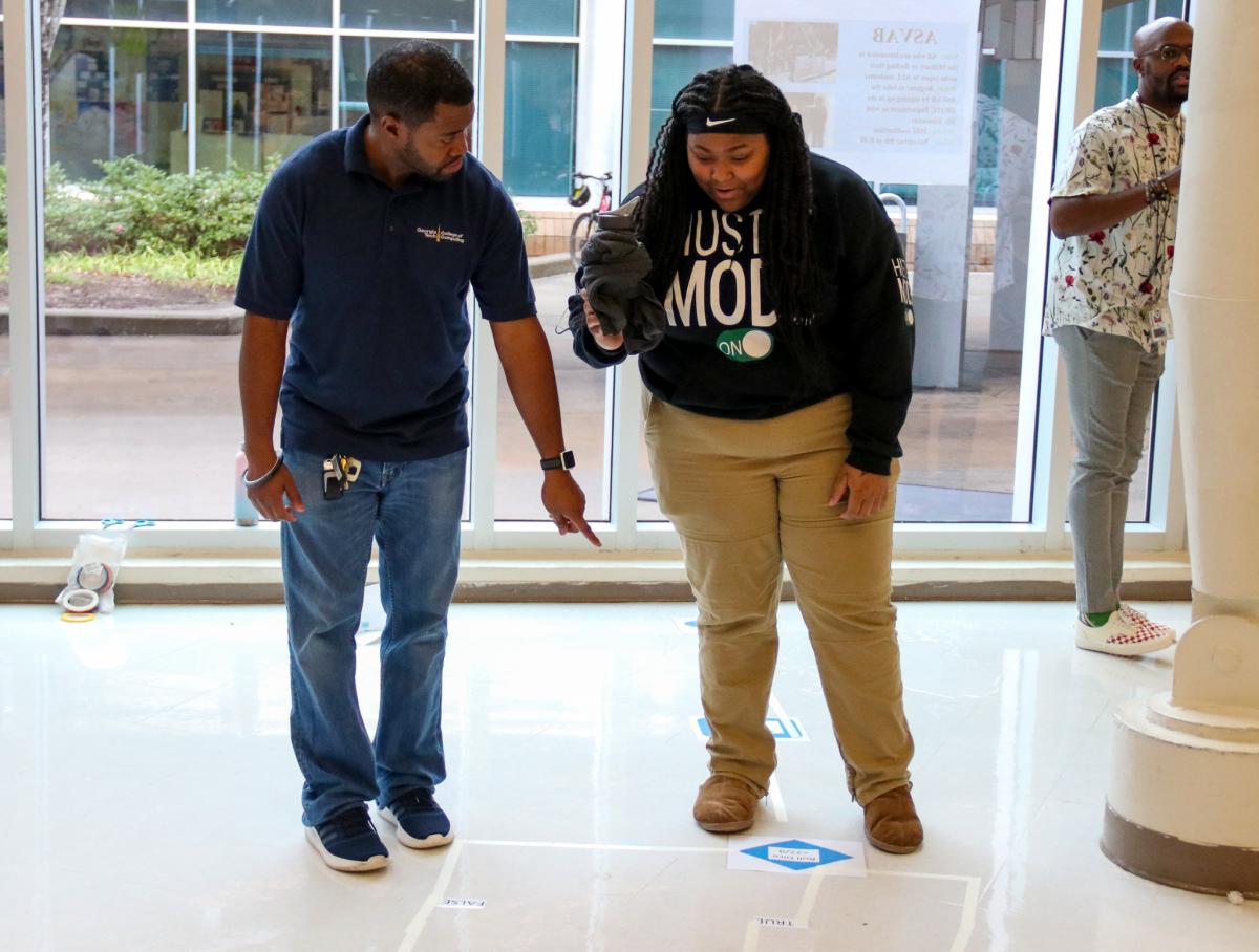 Foster walks a student through an unplugged activity.