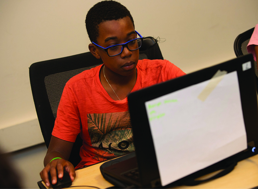 Boy works on computer.